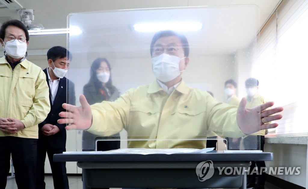 President Moon Jae-in checks a partition in a classroom at Osan High School in Yongsan Ward, Seoul, on Nov. 29, 2020. (Yonhap)