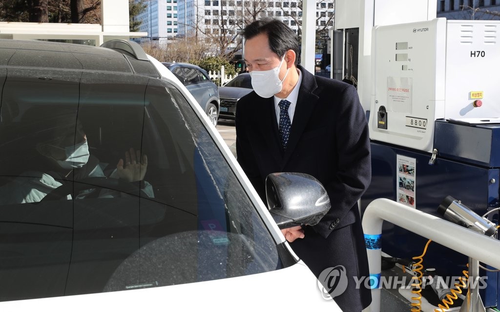 Rep. Woo Sang-ho (R) of the ruling Democratic Party speaks to a citizen at a hydrogen station in Seoul on Jan. 17, 2021. (Yonhap)