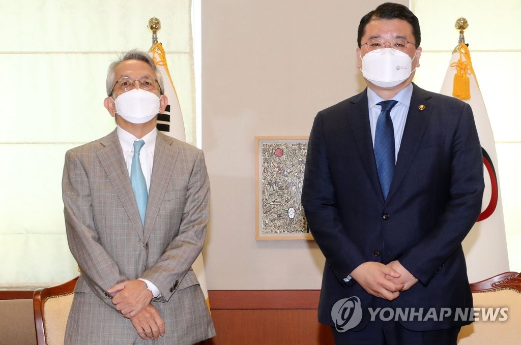 South Korean First Vice Foreign Minister Choi Jong-kun (R) poses for photo with new Japanese Ambassador to South Korea Koichi Aiboshi, ahead of their first meeting on Feb. 26, 2021. (Yonhap)
