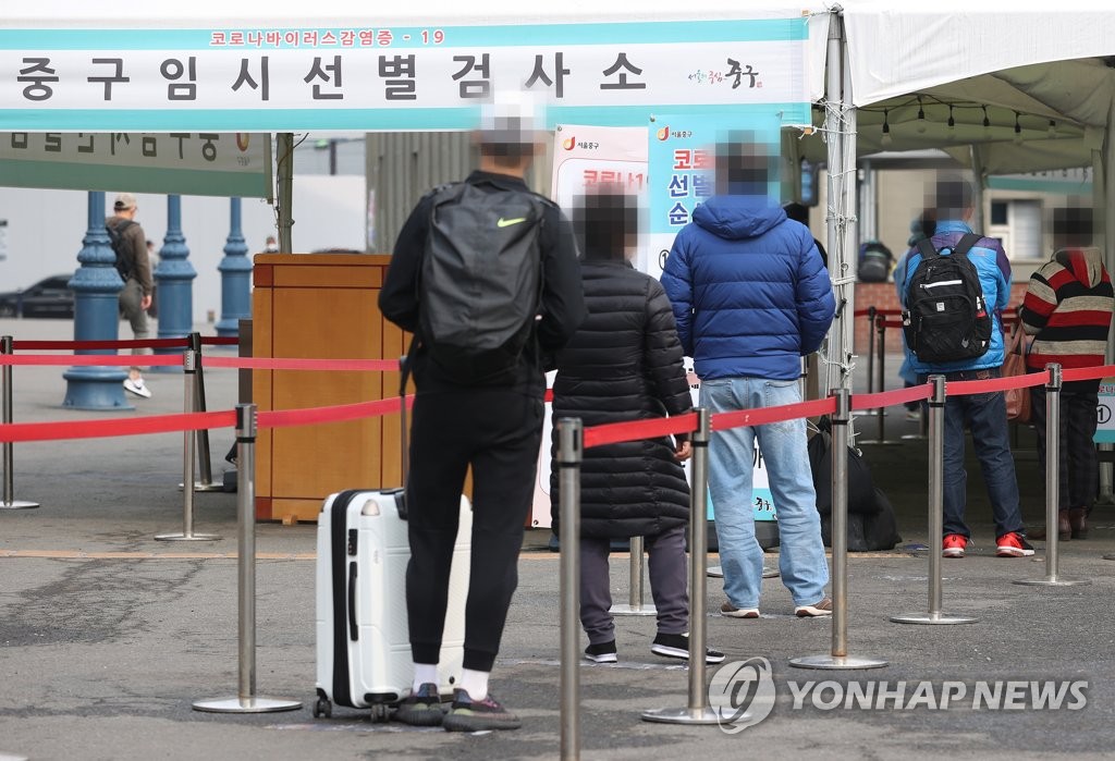 Citizens wait in line at a makeshift virus testing clinic in Seoul on March 13, 2021. (Yonhap)