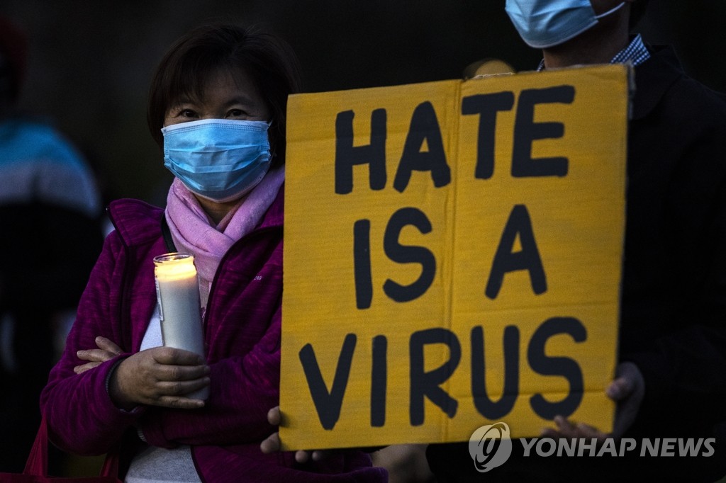 지난 3월 미국 캘리포니아주 앨햄브라에서 열린 아시아계 미국인에 대한 증오를 규탄하는 촛불집회에서 한 참가자가 '증오는 바이러스'라고 쓰인 팻말을 들고 있다. [EPA=연합뉴스 자료사진]