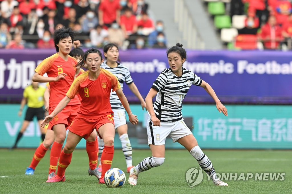 Choe Yu-ri of South Korea (R) battles Yao Wei of China for the ball during the teams' Olympic women's football qualifying match at Suzhou Olympic Sports Centre in Suzhou, China, on April 13, 2021, in this photo provided by the Korea Football Association. (PHOTO NOT FOR SALE) (Yonhap)