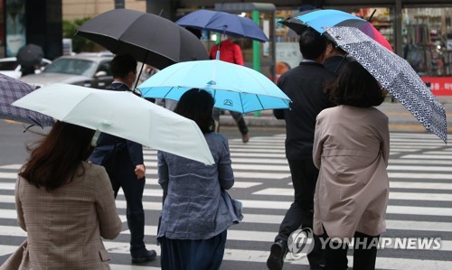 시민들이 우산으로 비바람을 막으며 걸어가고 있다. [연합뉴스 자료사진]