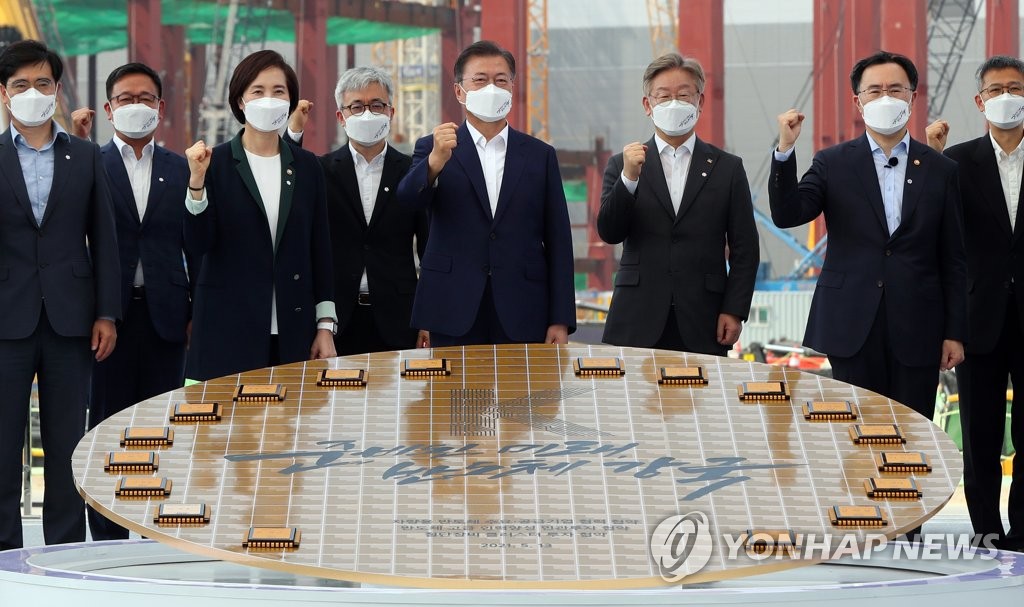President Moon Jae-in (4th from R) poses for a commemorative photo with other officials at the semiconductor production center of Samsung Electronics in Pyongtaek, Gyeonggi Province, on May 13, 2021. (Yonhap)
