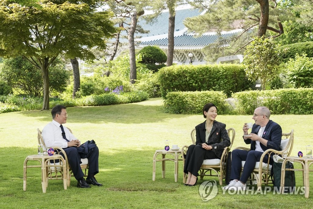 Le président Moon Jae-in (à g.) s'entretient avec Park Jin-hee (au c.), une actrice sud-coréenne, et Tyler Rasch, une personnalité de la télévision d'origine américaine, à Cheong Wa Dae à Séoul, le 27 mai 2021. (Photo fournie par Cheong Wa Dae. Revente et archivage interdits)