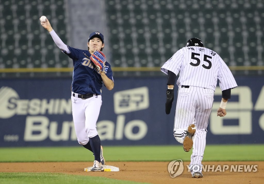 In this file photo from June 10, 2021, NC Dinos' second baseman Park Min-woo (L) throws to first to complete a double play against the LG Twins in the bottom of the fifth inning of a Korea Baseball Organization regular season game at Jamsil Baseball Stadium in Seoul. (Yonhap)