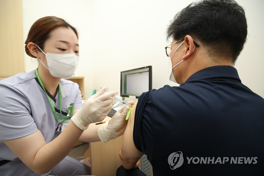 A man receives a COVID-19 vaccine shot at a medical facility in Seoul on July 26, 2021, as health authorities started a program the same day to inoculate people aged from 55 through 59 across the country. (Yonhap)