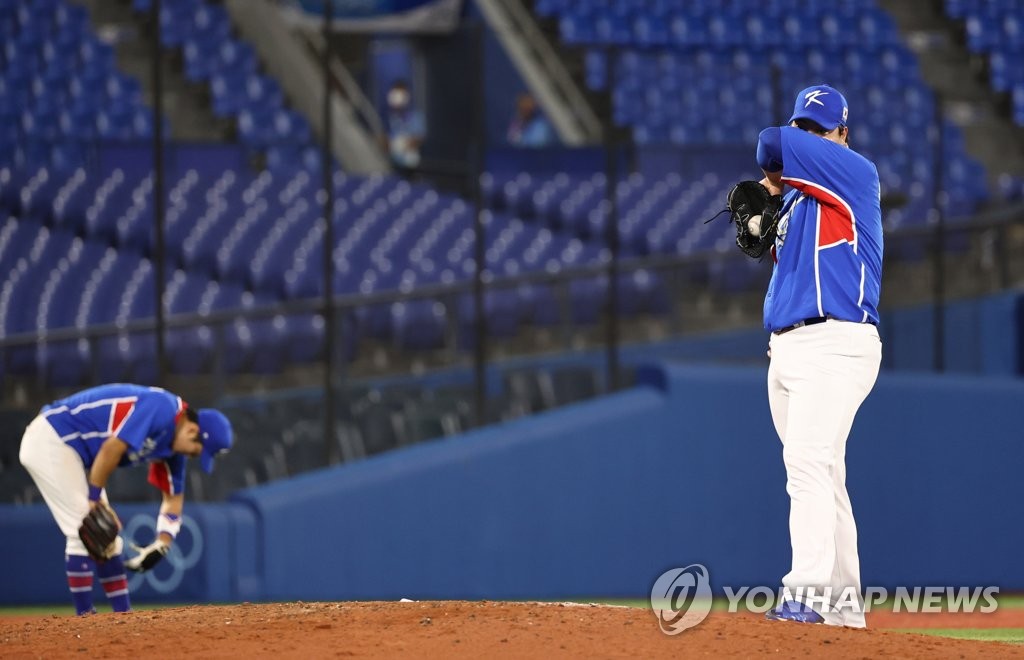 Cho Sang-woo of South Korea (R) reacts to a two-run single by Tyler Austin of the United States in the bottom of the sixth inning of the teams' semifinal game of the Tokyo Olympic baseball tournament at Yokohama Stadium in Yokohama, Japan, on Aug. 5, 2021. (Yonhap)
