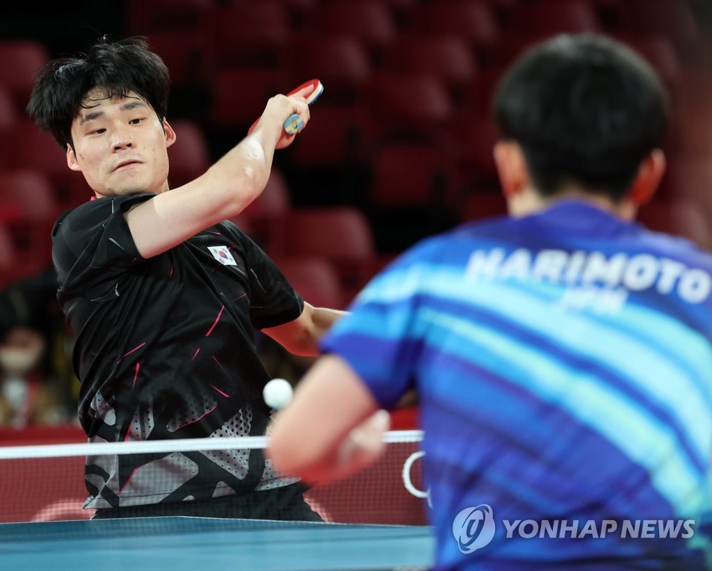 Jang Woo-jin of South Korea (L) hits a shot against Tomokazu Harimoto of Japan during their singles match of the bronze medal contest for the men's table tennis team event at the Tokyo Olympics at Tokyo Metropolitan Gymnasium in Tokyo on Aug. 6, 2021. (Yonhap)