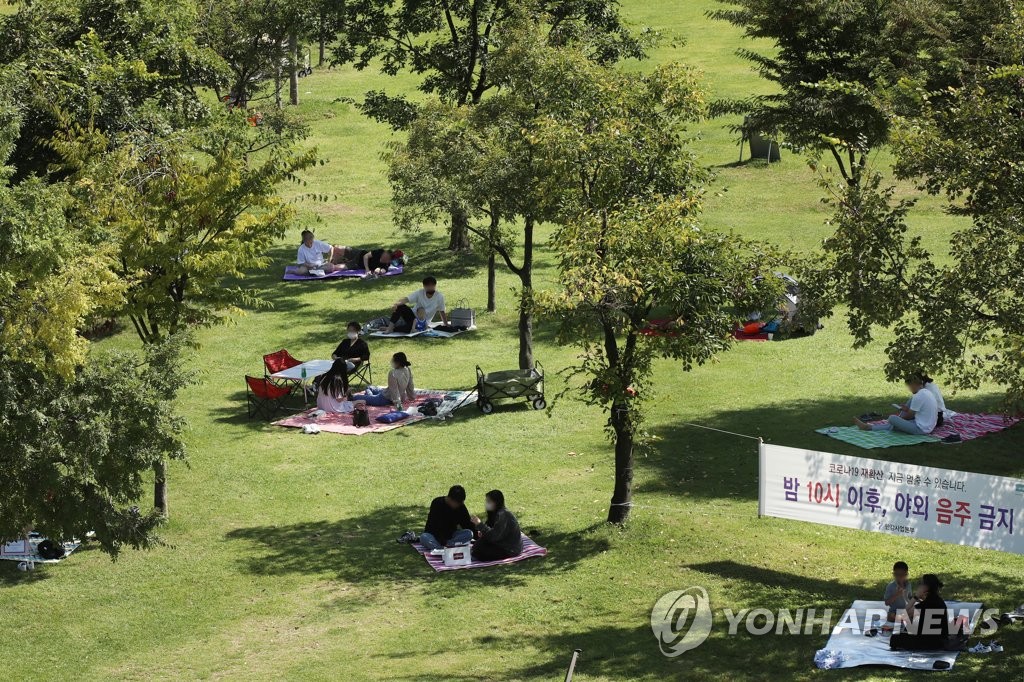Families and groups of people enjoying picnics under government-mandated social distancing guidelines at a park on the banks of the Han River in Yeouido, western Seoul, in the Sept. 12, 2021, file photo. (Yonhap)