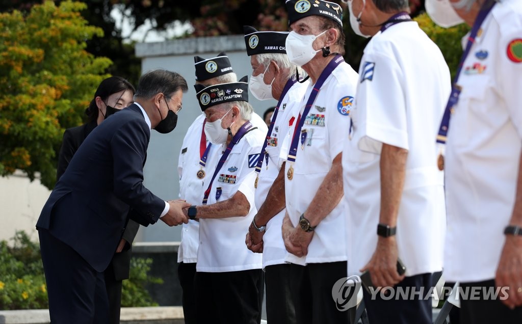 South Korean President Moon Jae-in shakes hands with a Korean War veteran during a visit to the National Memorial Cemetery of the Pacific in Hawaii on Sept. 22, 2021. (Yonhap)