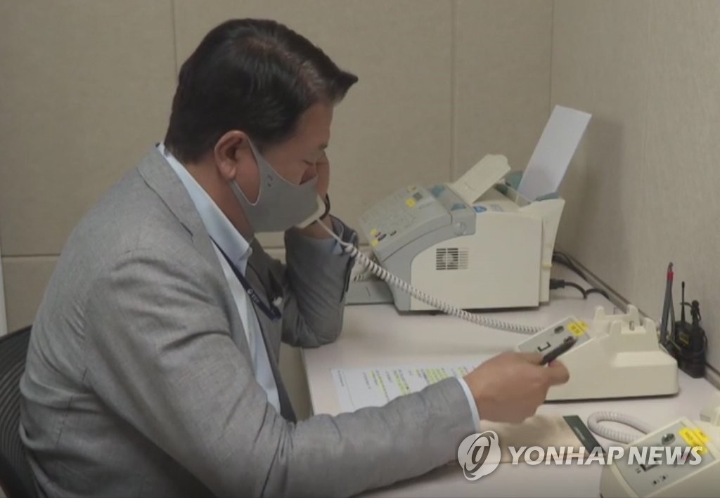 This file photo, provided by the unification ministry, shows a South Korean liaison officer talking to his North Korean counterpart at the Seoul bureau of their joint liaison office on Oct. 4, 2021. (PHOTO NOT FOR SALE) (Yonhap)