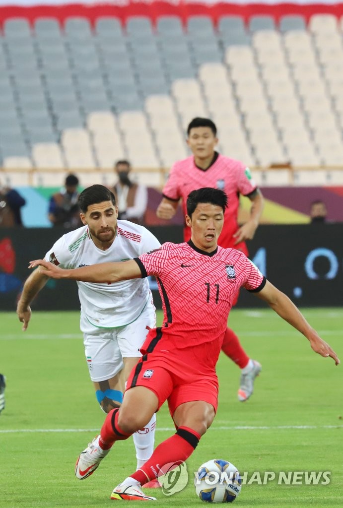 Hwang Hee-chan of South Korea (R) controls the ball against Iran during the teams' Group A match in the final Asian qualifying round for the 2022 FIFA World Cup at Azadi Stadium in Tehran on Oct. 12, 2021. (Yonhap)