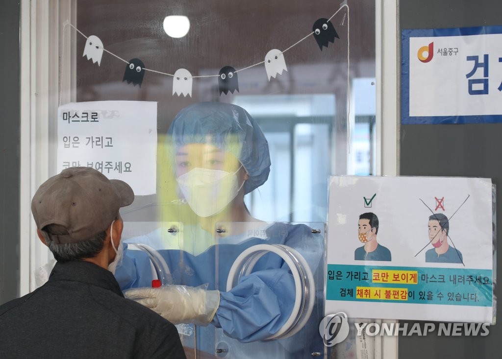 A health worker conducts a COVID-19 test at a testing site near Seoul Station in central Seoul on Oct. 24, 2021. (Yonhap)