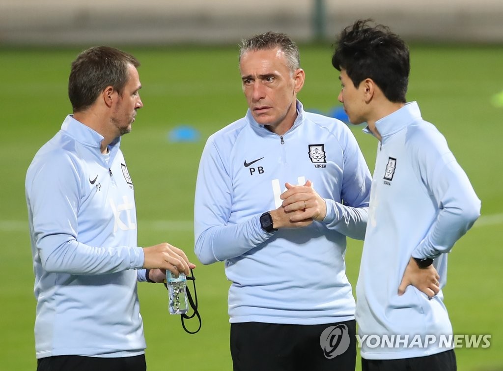 Paulo Bento (C), head coach of the South Korean men's national football team, speaks with his staff before a training session at Al-Sailiya Sports Club in Doha on Nov. 14, 2021, in preparation for a World Cup qualifying match against Iraq. (Yonhap)