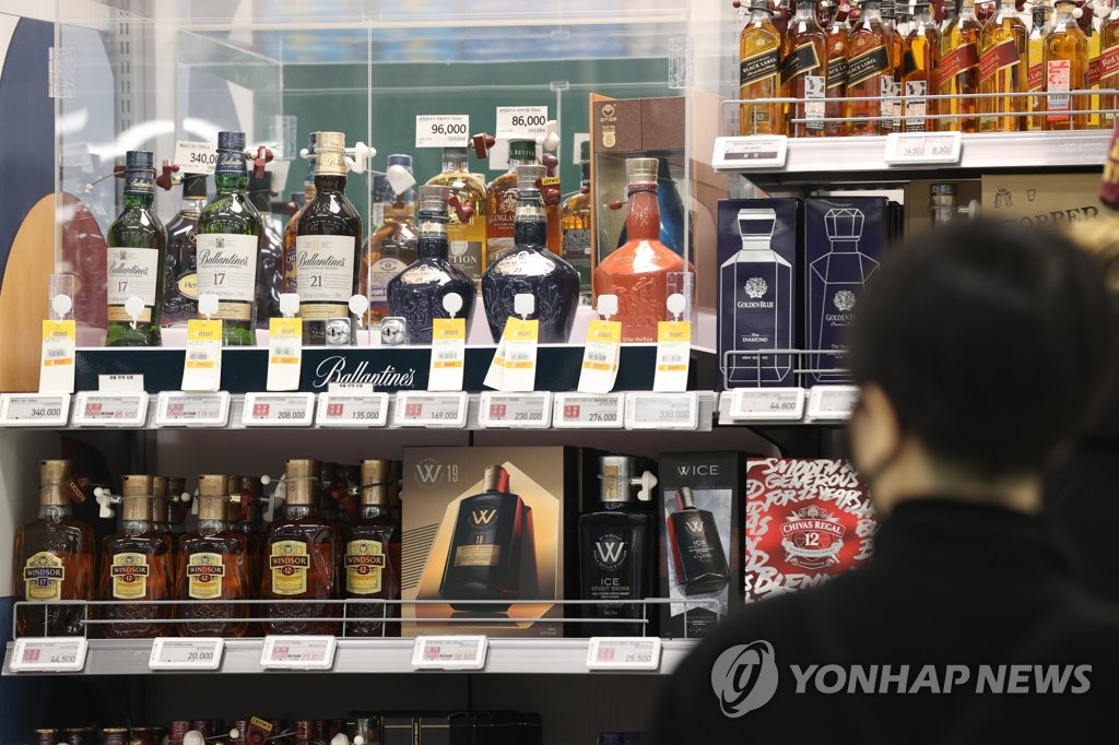 A shopper looks at a selection of whiskey at a large discount supermarket in Seoul on Jan. 12, 2022. (Yonhap) 