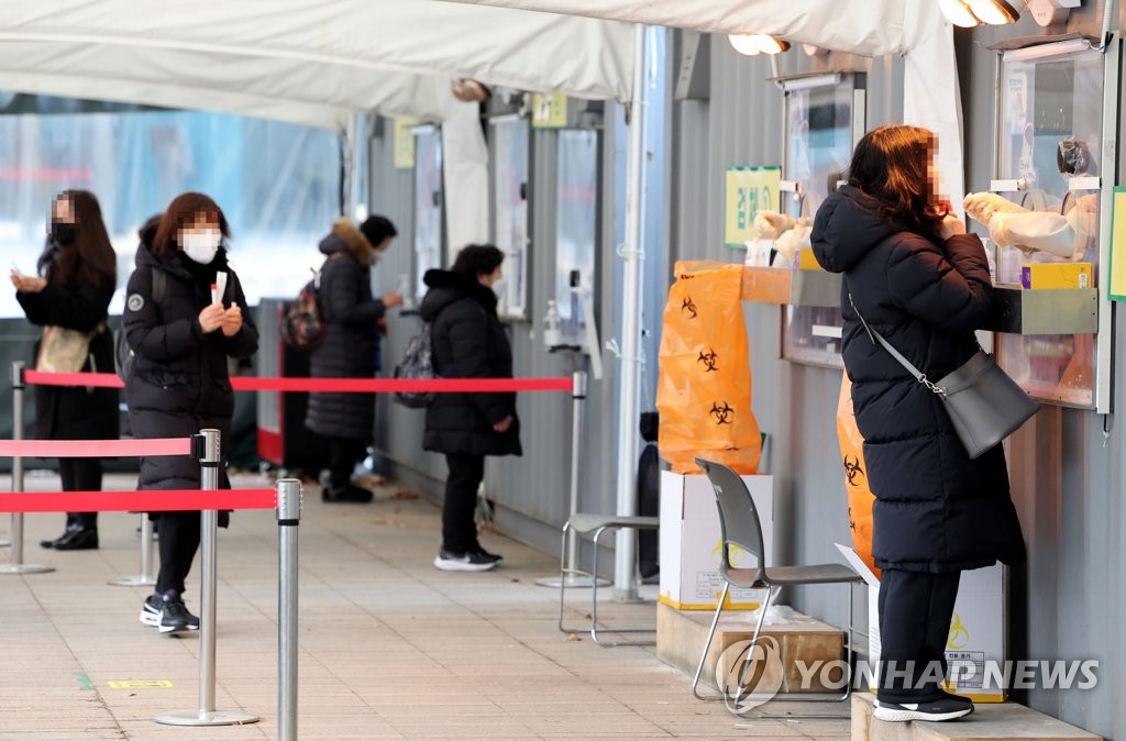 People take COVID-19 tests at a testing site near Seoul City Hall in Seoul on Jan. 15, 2022. (Yonhap)