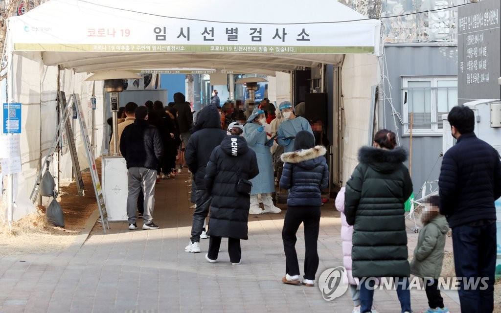 A long line of people waiting to take COVID-19 tests is formed at a temporary testing booth in front of a subway station in Incheon, 40 kilometers west of Seoul, on Jan. 27, 2022. (Yonhap)