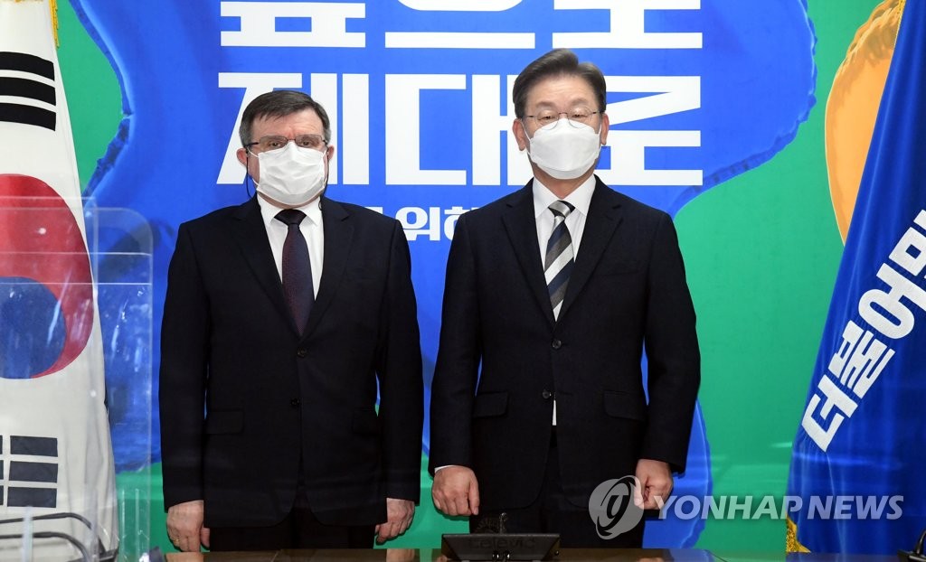 Lee Jae-myung (R), the presidential candidate of the ruling Democratic Party (DP), and Russian Ambassador to South Korea Andrey Kulik pose for a photo ahead of their meeting at the DP's headquarters in Seoul on Feb. 9, 2022. (Pool photo) (Yonhap)