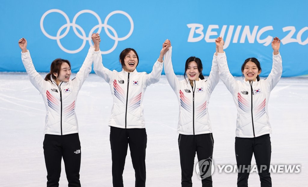 Les patineuses de vitesse sud-coréennes Choi Min-jeong, Kim A-lang, Lee Yu-bin et Seo Whi-min (de g. à dr.) célèbrent leur médaille d'argent du relais féminin de patinage de vitesse sur piste courte sur 3.000m aux Jeux olympiques d'hiver de Pékin au Palais omnisports de la capitale à Pékin, le 13 février 2022.