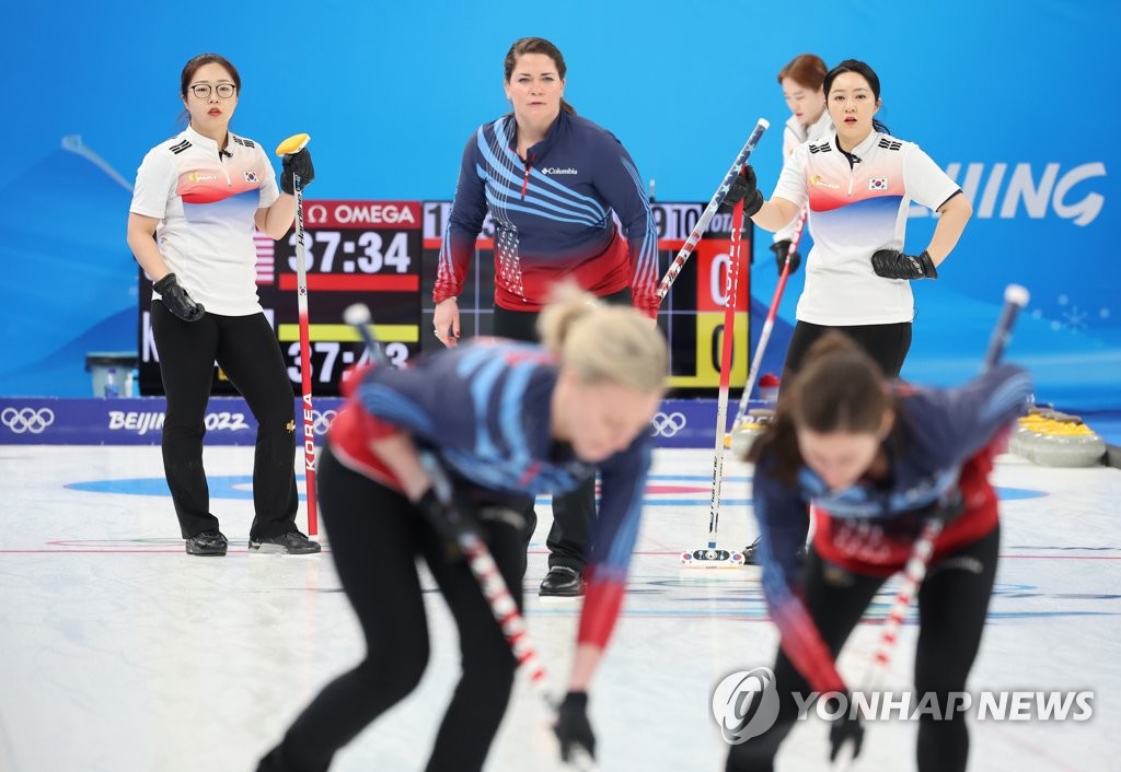 Les Etats-Unis (en bleu et rouge) et la Corée du Sud s'affrontent lors d'un match de groupe en curling féminin aux Jeux olympiques d'hiver de Pékin, le lundi 14 février 2022, au Centre aquatique national à Pékin. 