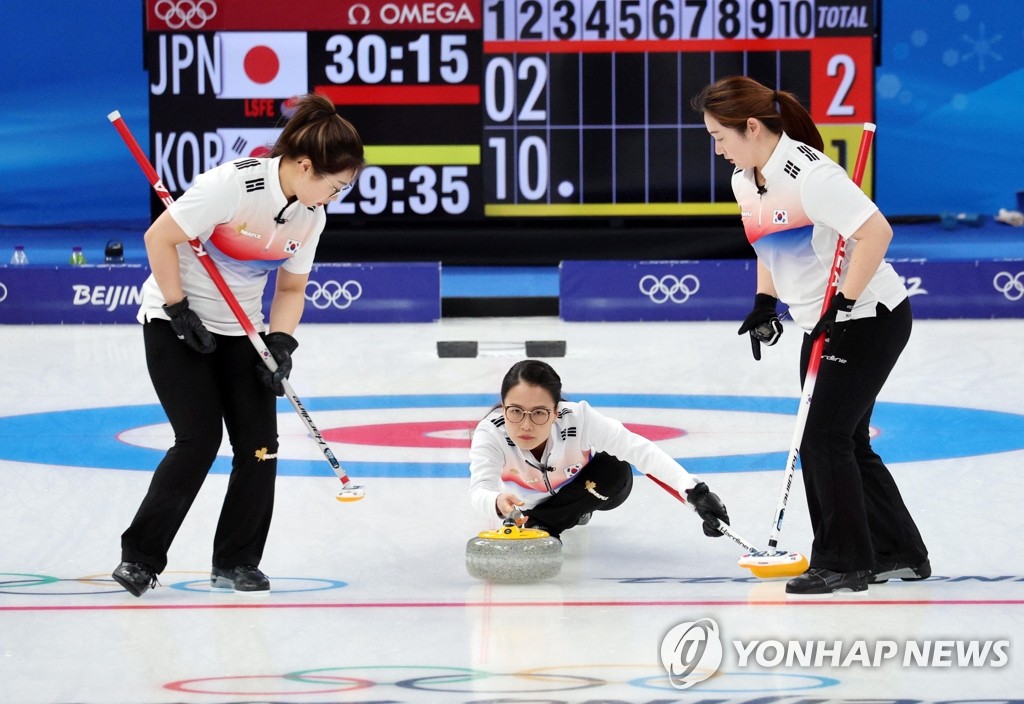 South Korean skip Kim Eun-jung (C) delivers a stone during a match against Japan in the women's curling round-robin session at the Beijing Winter Olympics at the National Aquatics Centre on Feb. 14, 2022. (Yonhap)