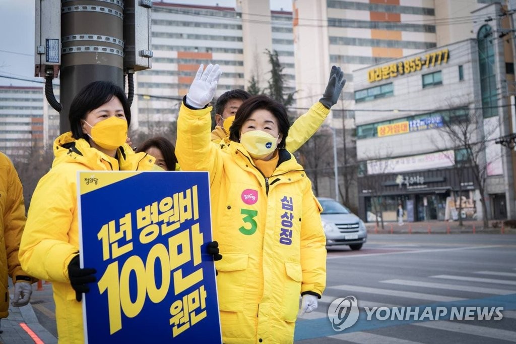 Sim Sang-jeung (R), the presidential candidate of the minor progressive Justice Party, waves to people going to work in Iksan, North Jeolla Province, on Feb. 15, 2022, in this photo provided by her party. (PHOTO NOT FOR SALE) (Yonhap)