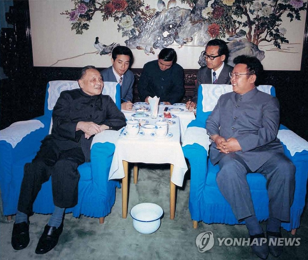 This image from a photo book released by North Korea's Foreign Languages Publishing House on Feb. 16, 2022, shows Kim Jong-il (R) and then Chinese leader Deng Xiaoping (L) during Kim's visit to China in 1983. (PHOTO NOT FOR SALE) (Yonhap)