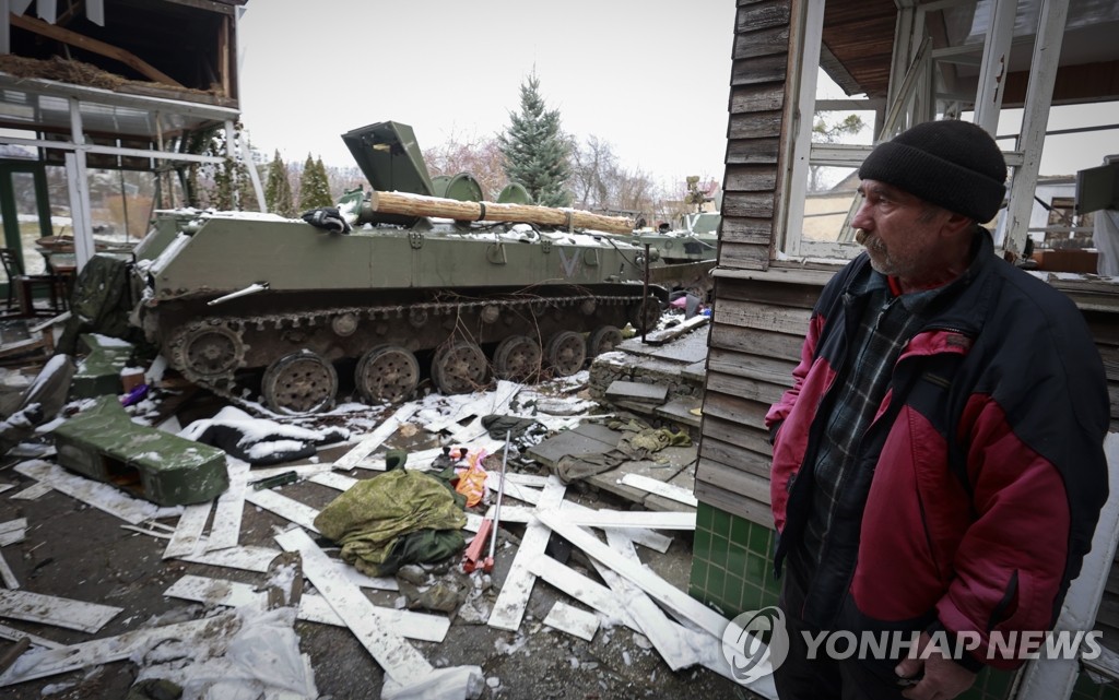 파괴된 러시아 군용 차량 바라보는 우크라 주민