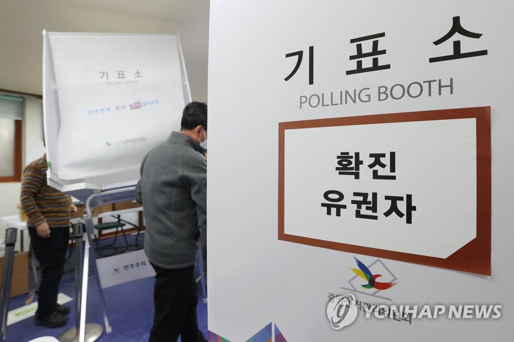 Government officials prepare to set up polling booths for COVID-19 patients at a site in Jongno, central Seoul, on March 8, 2022, one day before South Korea holds a presidential election. (Yonhap)