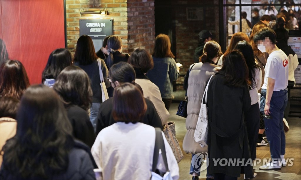 Los fanes de la sensación del K-pop BTS esperan en fila, el 12 de marzo de 2022, para ingresar en una sala de cine, en el distrito de Yongsang, en el centro de Seúl, para ver el concierto del grupo "Permission To Dance On Stage - Seoul", transmitido en vivo.