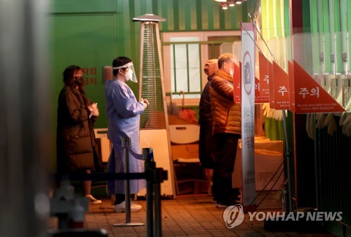 People wait in line to get tested for COVID-19 at a temporary testing station at World Cup Park in western Seoul on March 15, 2022. (Yonhap)