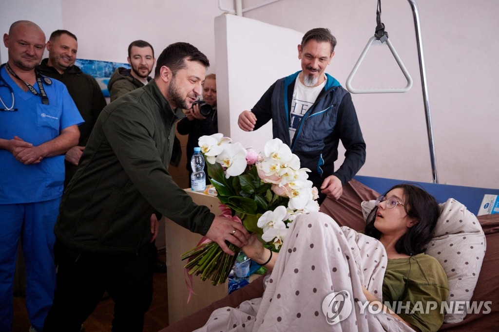 O presidente ucraniano distribui um buquê de flores para a menina ferida durante o processo de evacuação