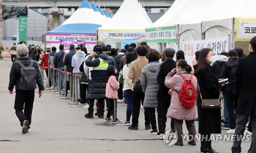 ソウル駅前の広場にある新型コロナの検査所で大勢の市民が検査の順番を待っている＝１８日、ソウル（聯合ニュース）