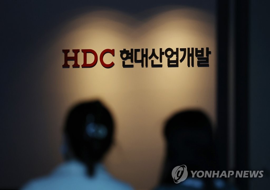 Workers enter the headquarters of HDC Hyundai Development Co. in Seoul on March 28, 2022. (Yonhap)