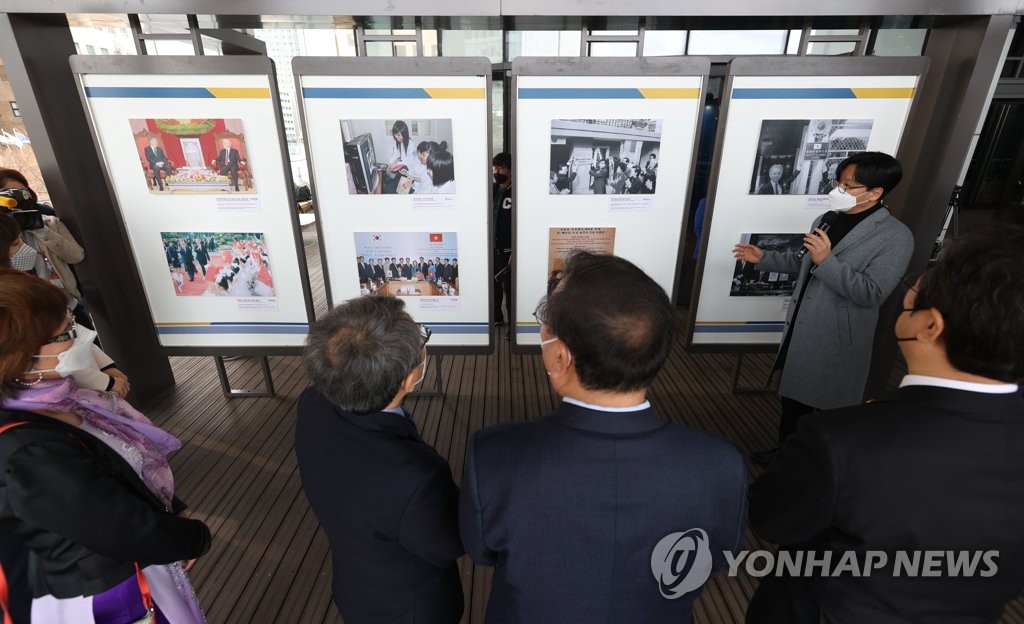 Guests look at photos on display during a press photo exhibition at the National Museum of Korean Contemporary History in central Seoul on March 31, 2022. Co-hosted by South Korea's Yonhap News Agency and Vietnam News Agency (VNA) and the museum, the exhibit runs from March 31-May 5. (Yonhap)