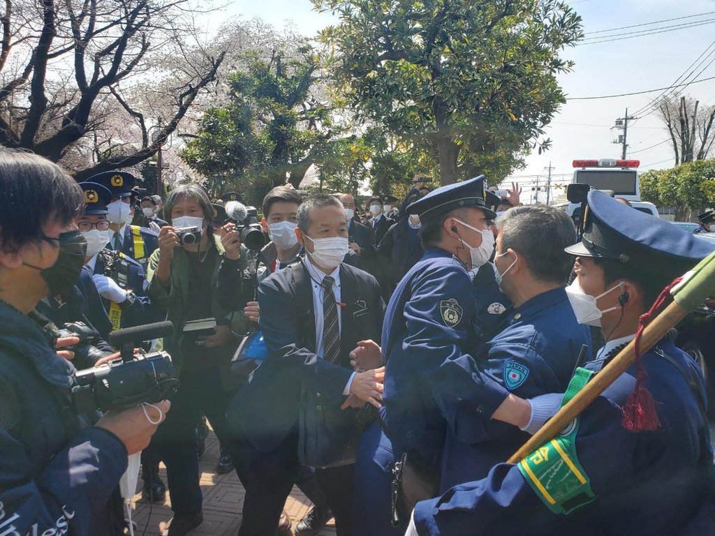 「表現の不自由展　東京２０２２」の会場に侵入しようとして警察に阻まれる反対派団体の関係者＝２日、東京（聯合ニュース）