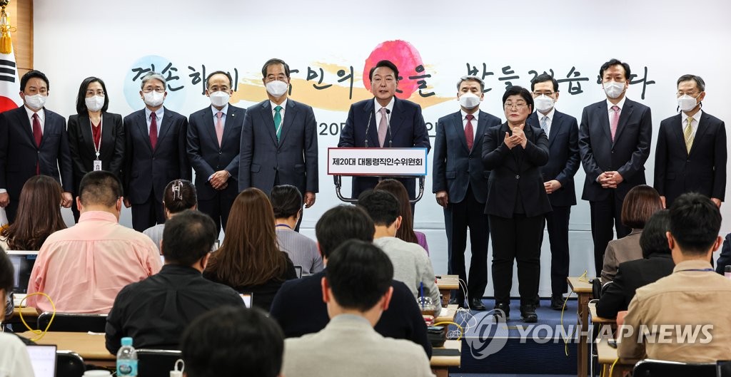 Le président élu Yoon Suk-yeol (au centre) annonce le dimanche 10 avril 2022 ses nominations pour huit membres du gouvernement au bureau du comité de transition à Séoul, entouré des ministres désignés et du candidat au poste de Premier minsitre Han Duck-soo (5e de la g.). 