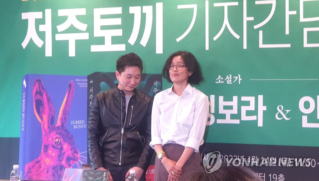 Chung Bora (dcha.), autora de "Cursed Bunny", y su traductor, Anton Hur, posan ante la cámara, el 14 de abril de 2022, durante una conferencia de prensa en Seúl.