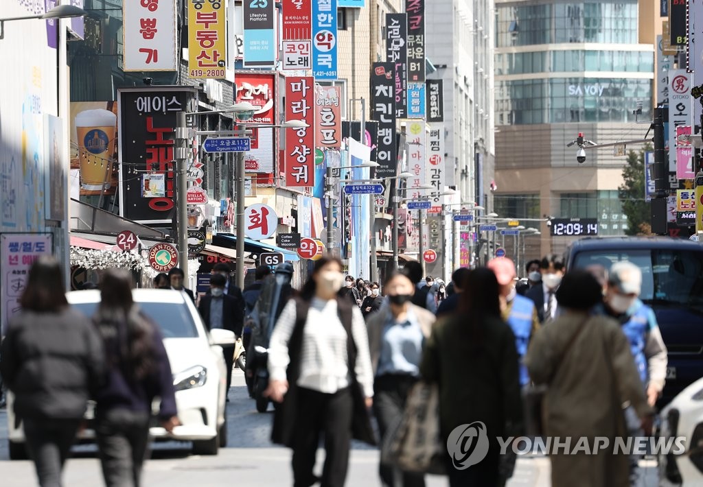 People walk down a street in central Seoul on April 15, 2022. Starting next week, South Korea will lift all COVID-19 social distancing rules, except the mask mandate, in the first big step toward a return to normalcy since the country reported its first COVID-19 outbreak in January 2020. (Yonhap)