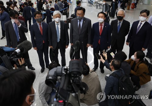 仁川国際空港で報道陣に囲まれる代表団のメンバー＝２８日、仁川（聯合ニュース）