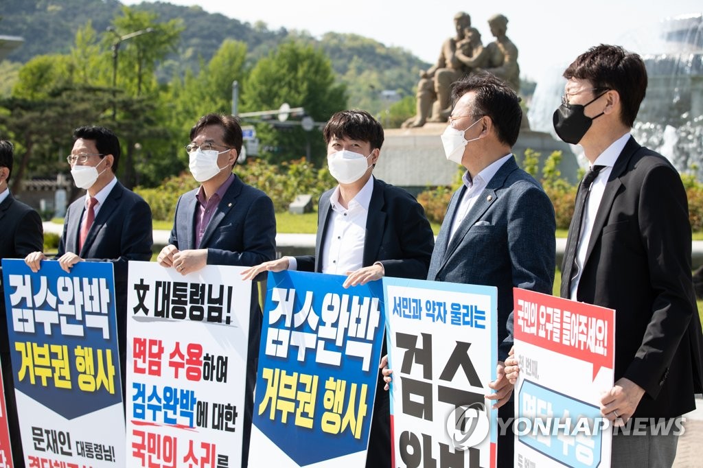 Lawmakers of the main opposition People Power Party, including Chairman Lee Jun-seok (C), display signs demanding President Moon Jae-in veto controversial legislation on prosecution reform, outside Cheong Wa Dae in Seoul on May 1, 2022. (Pool photo) (Yonhap)