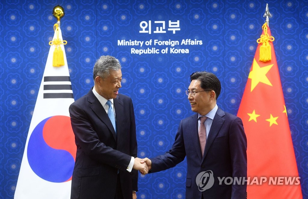 Noh Kyu-duk (R), special representative for Korean Peninsula peace and security affairs, shakes hands with his Chinese counterpart, Liu Xiaoming, ahead of their meeting at the Ministry of Foreign Affairs on May 3, 2022. (Pool photo) (Yonhap) 