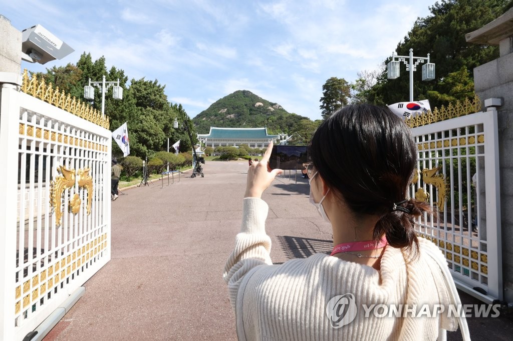 青瓦台前で写真を撮る市民（政権引き継ぎ委員会写真記者団）＝１０日、ソウル（聯合ニュース）