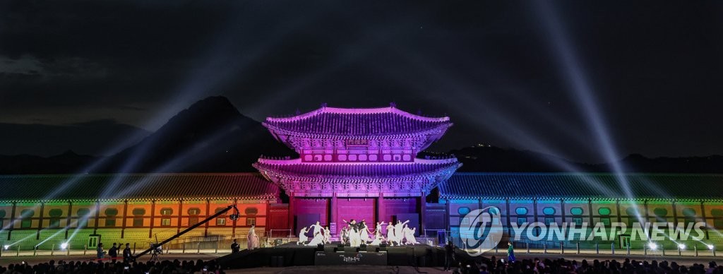 Des danceurs traditionnels présentent le mardi 10 mai 2022 un spectacle devant la porte Heungnyemun illuminée au palais de Gyeongbok pour l'ouverture du Festival culturel royal.