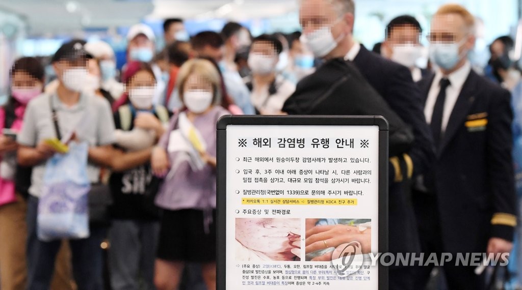 ５月２７日、仁川国際空港で韓国入国前に検疫を受けようと待つ人たち＝（聯合ニュース）