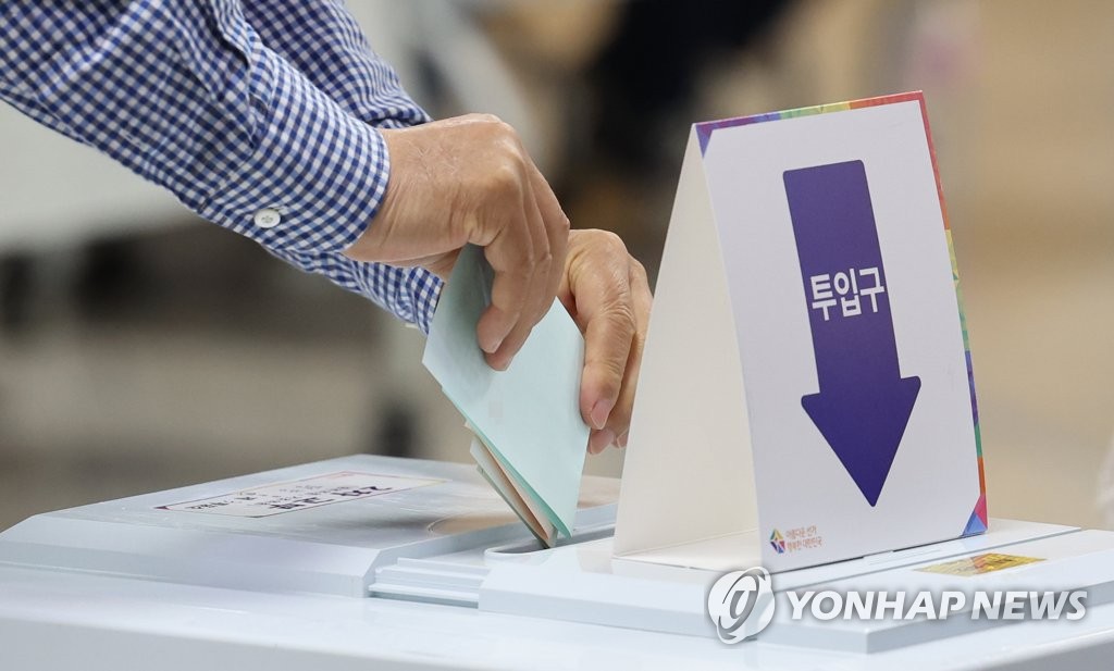 ソウル市内の投票所で投票に参加する有権者=１日、ソウル（聯合ニュース）