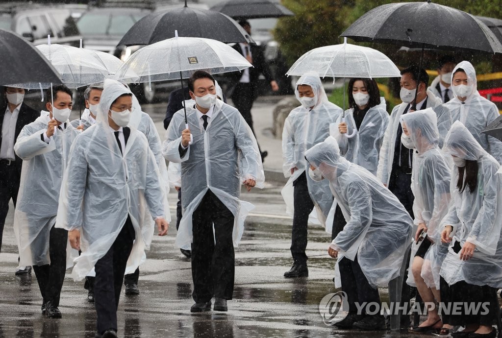 El presidente surcoreano, Yoon Suk-yeol (3º por la izda.), llega, el 6 de junio de 2022, al Cementerio Nacional de Seúl, en el distrito de Dongjak, en la capital surcoreana, para asistir a una ceremonia por el 67º aniversario del Día de los Caídos.