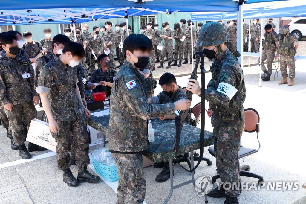 Des réservistes reçoivent le mardi 21 juin 2022 des fusils dans une unité de l'armée de terre à Chuncheon, dans la province du Gangwon, alors qu'un programme d'entraînement annuel sur le terrain a été relancé après sa suspension pendant deux ans en raison de la pandémie de nouveau coronavirus (Covid-19). 