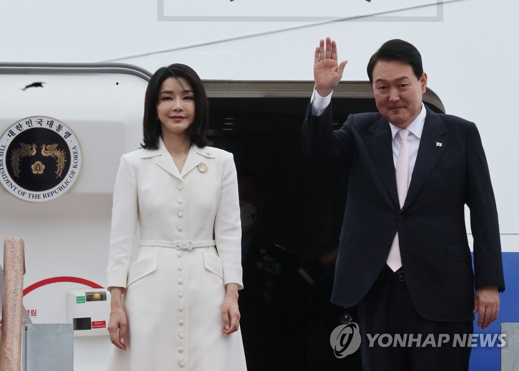 La foto, tomada el 27 de junio de 2022, muestra al presidente surcoreano, Yoon Suk-yeol (dcha.), y la primera dama, Kim Keon-hee, saludando antes de subir al avión presidencial que partirá a España para asistir a una cumbre de la Organización del Tratado del Atlántico Norte (OTAN), en el Aeropuerto de Seúl, en Seongnam, al sur de la capital surcoreana. 